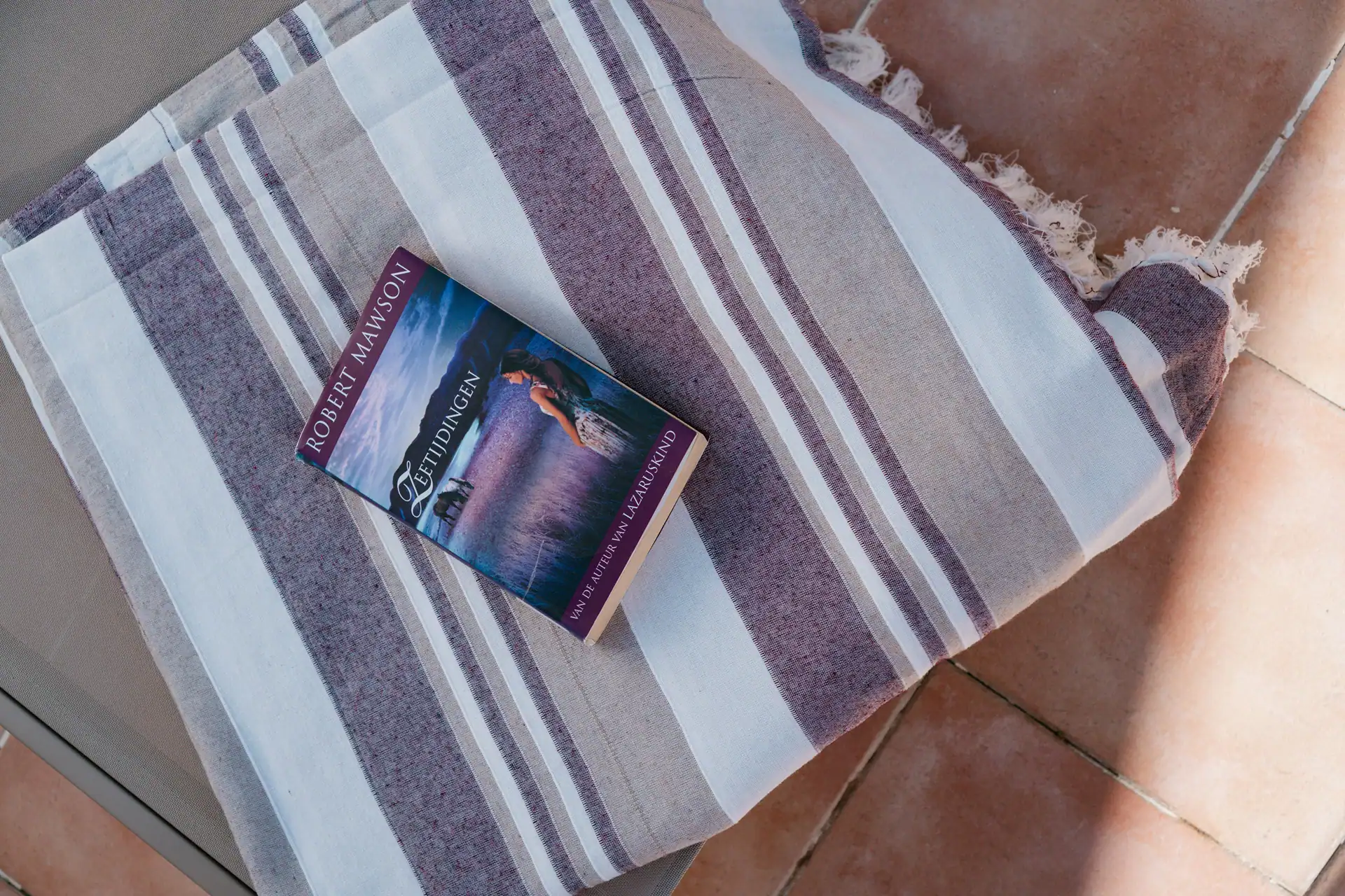 boek op een donker rood met beige en wit laken